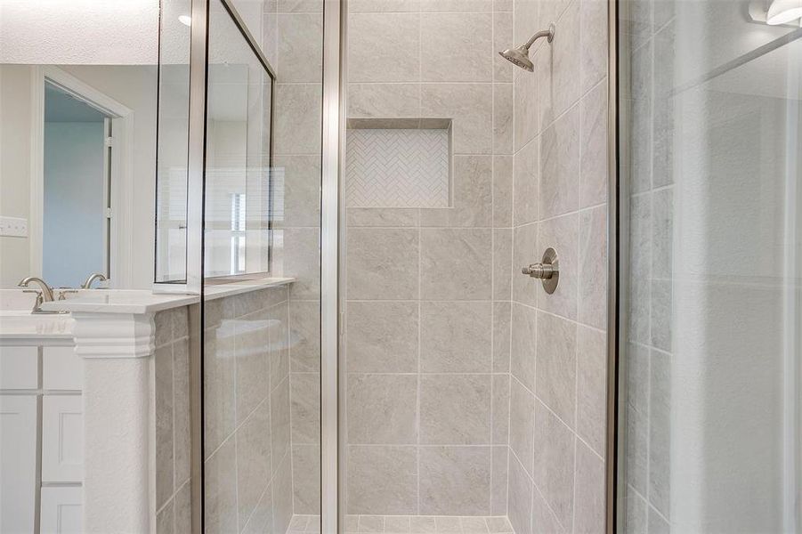 Bathroom with a shower with shower door and vanity