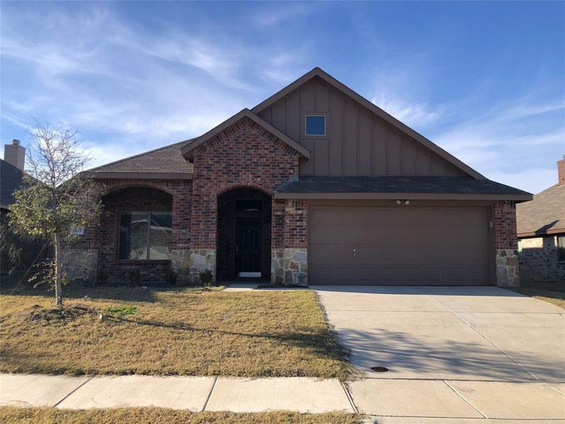 View of front of property featuring a front lawn and a garage