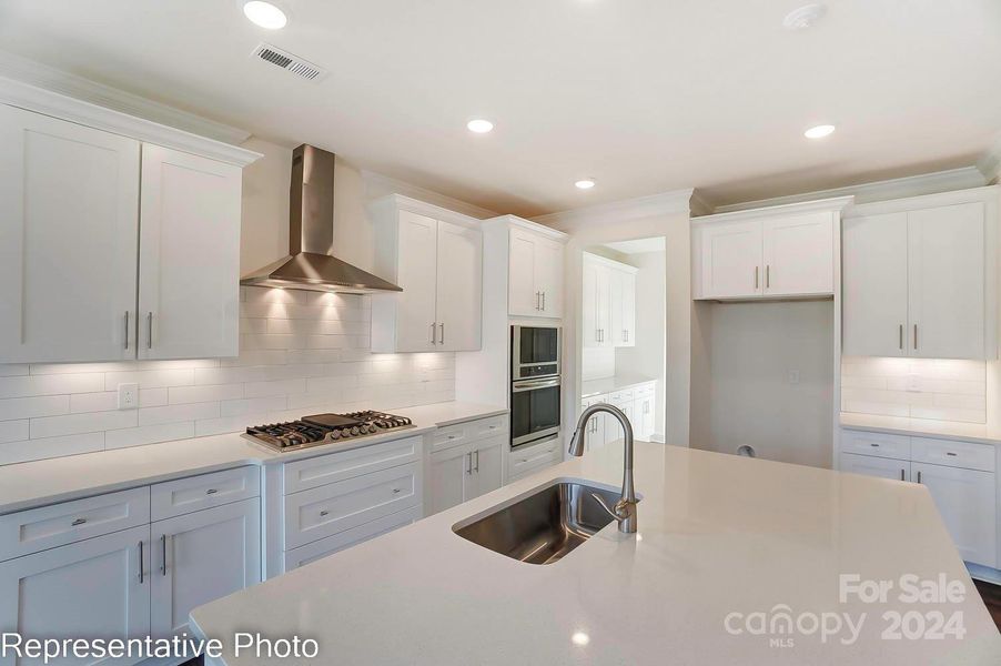 Designer Kitchen with white quartz counters and white cabinets