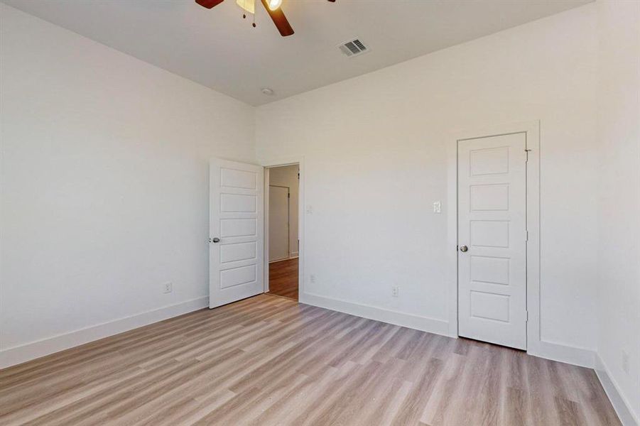 Empty room with ceiling fan and light hardwood / wood-style flooring