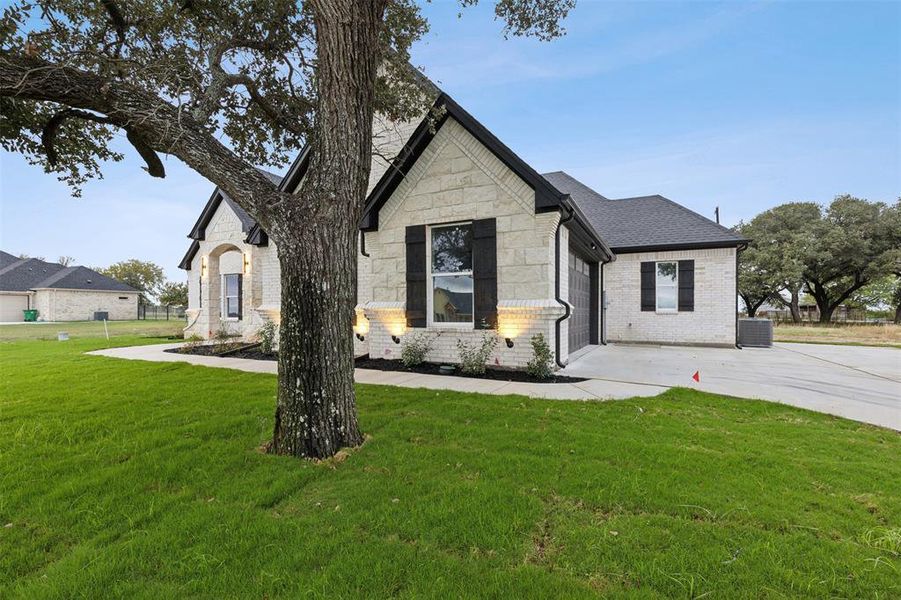 View of front of house with a front lawn and central AC