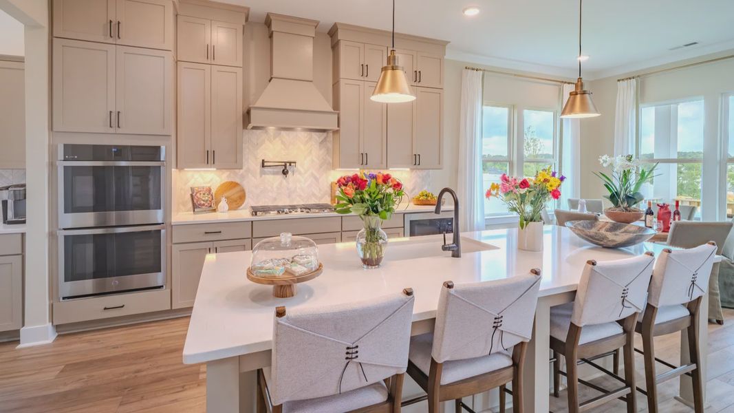 Kitchen with tile backsplash, quartz countertops, and pendant lighting Kitchen with tile backsplash, quartz countertops, and pendant lighting
