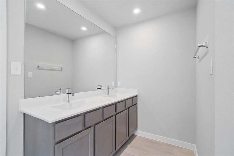 This large primary bath is spacious enough to share! With separate vanities, plentiful cabinet and counter space, you are sure to have private area while sharing this bathroom!