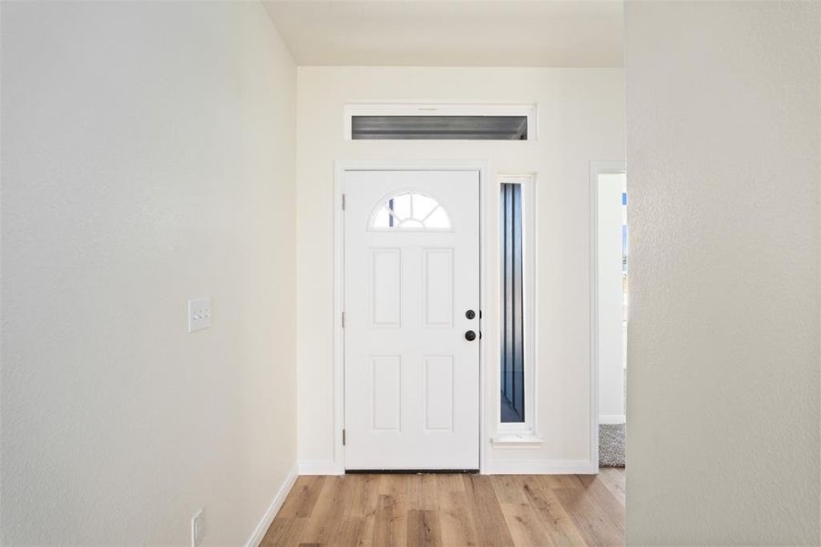 Foyer featuring light wood-style flooring and accent windows for natural light Foyer featuring light wood-style flooring and accent windows for natural light