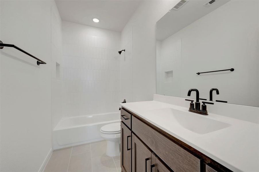 Modern bathroom featuring a wood-finish vanity with a single basin sink and a stone-finish countertop