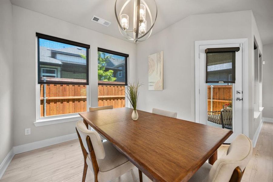 Dining room featuring a chandelier and light wood-style flooring Dining room featuring a chandelier and light wood-style flooring
