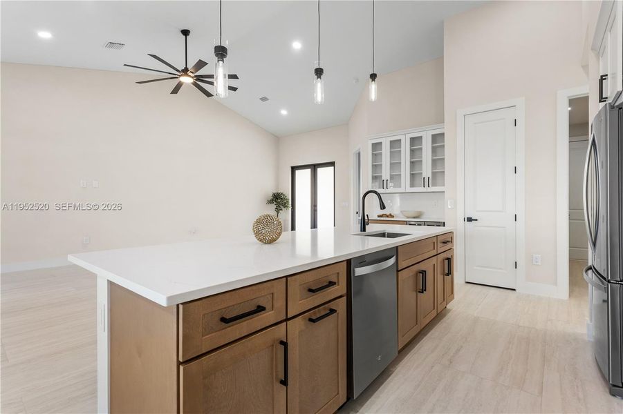 Crisp WHITE SHAKER CABINETRY is paired w/ contrasting warm WOOD-TONE ISLAND CABINETS & modern BLACK HARDWARE for a sophisticated coastal-modern design.