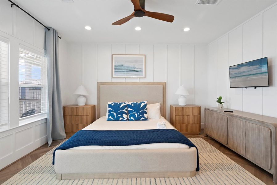 Second-Floor Primary Suite — A true haven of comfort and sophistication. This front-facing retreat features a spacious layout with a sun-drenched window, elegant bedside lighting, and a mounted TV above a sleek cabinet for modern convenience. The plush area rug grounds the room in warmth and texture, adding a layer of refined comfort to this upscale escape. Second-Floor Primary Suite — A true haven of comfort and sophistication. This front-facing retreat features a spacious layout with a sun-drenched window, elegant bedside lighting, and a mounted TV above a sleek cabinet for modern convenience. The plush area rug grounds the room in warmth and texture, adding a layer of refined comfort to this upscale escape.