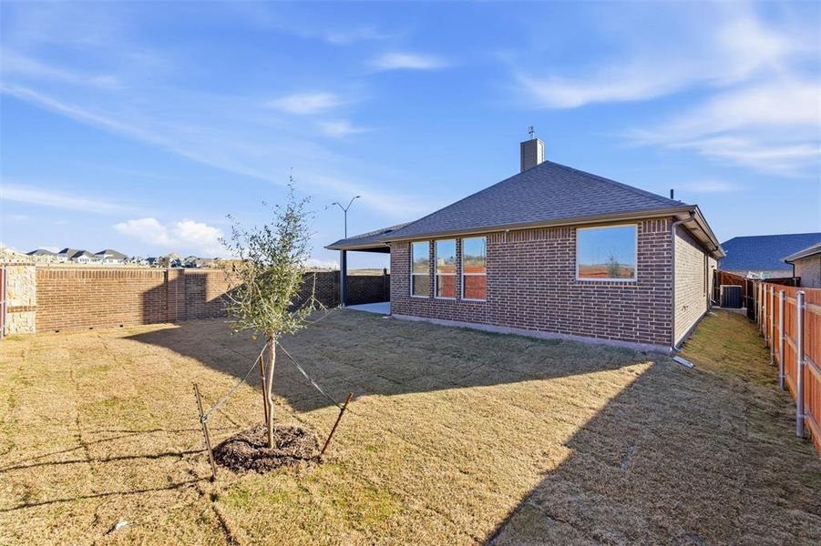 Back of house with a fenced backyard, a patio, a chimney, a shingled roof, and brick siding