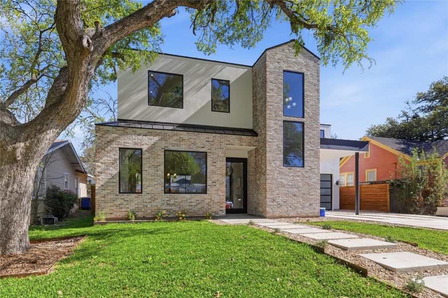 Modern architecture defines this dwelling, with a smooth path guiding guests through a lush, green lawn. Modern architecture defines this dwelling, with a smooth path guiding guests through a lush, green lawn.