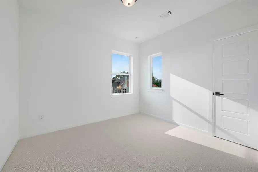 Neutral-toned wall-to-wall carpeting complements bright white walls