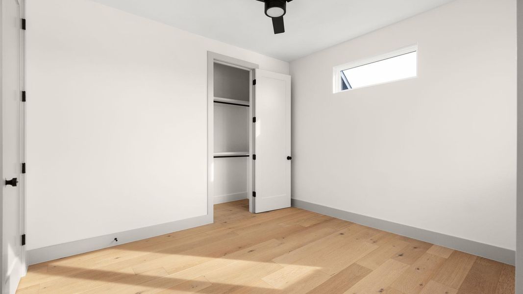 Unfurnished bedroom with ceiling fan and light wood-type flooring