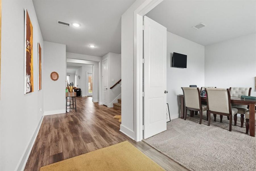 Hall featuring wood-style finished floors, stairs, and recessed lighting Hall featuring wood-style finished floors, stairs, and recessed lighting