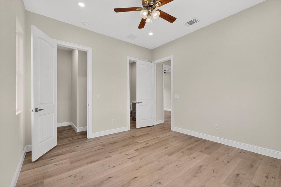 Smooth wood floors and crisp neutral walls define this versatile secondary bedroom space.