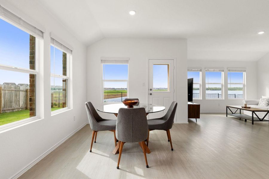 Natural light pours into this dining area with a water view.
