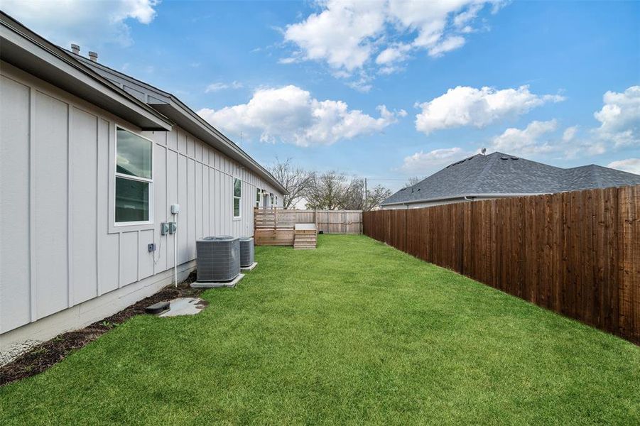 View of yard with cooling unit and a fenced backyard