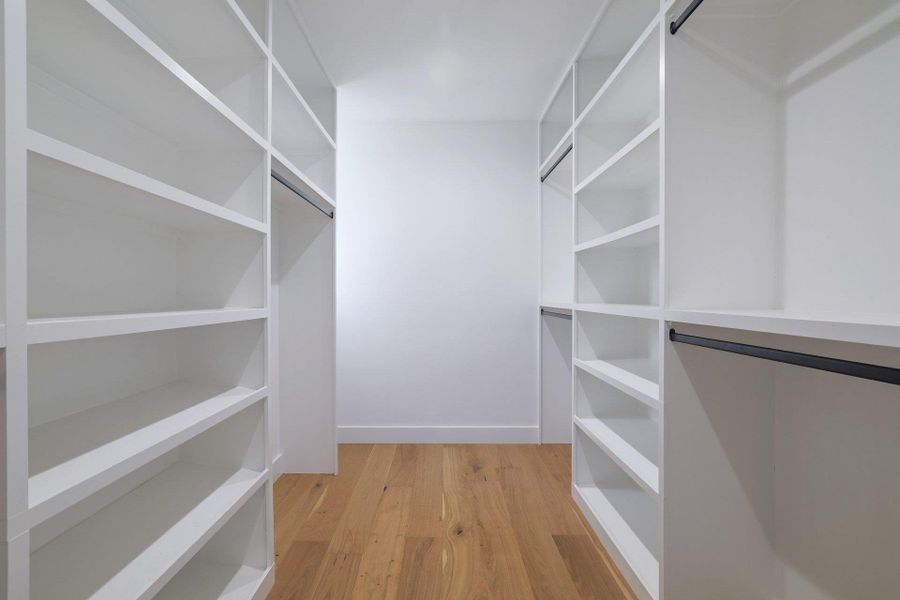 Walk in closet with light wood-style flooring