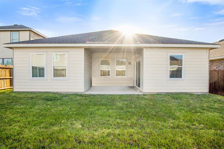 Rear view of house featuring a shingled roof and a covered patio area
