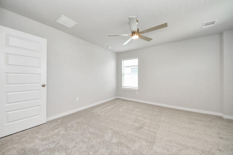 Secondary bedroom features plush carpeting, large windows that let in plenty of natural light, bright paint, and spacious closets. Sample photo of completed home with similar floor plan. Actual colors and selections may vary. Secondary bedroom features plush carpeting, large windows that let in plenty of natural light, bright paint, and spacious closets. Sample photo of completed home with similar floor plan. Actual colors and selections may vary.