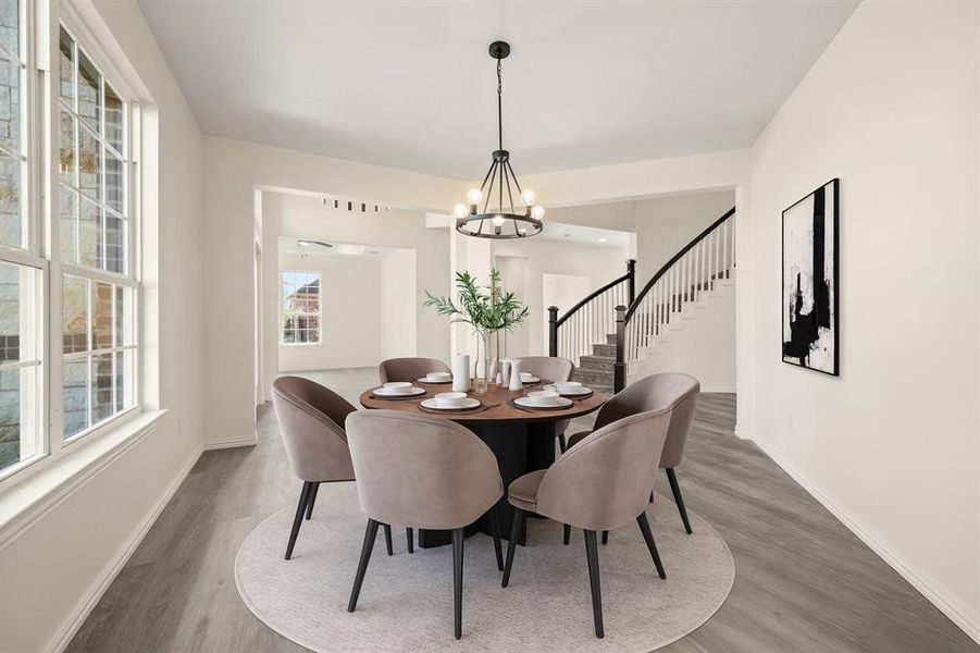 Dining area with wood finished floors, stairs, and a chandelier Dining area with wood finished floors, stairs, and a chandelier