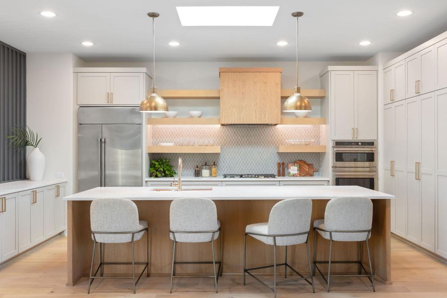 Kitchen with open shelves, a sink, light wood-style floors, appliances with stainless steel finishes, and a skylight