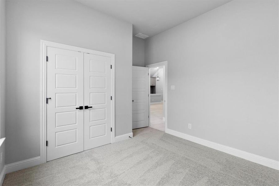 Unfurnished bedroom with light colored carpet and a closet