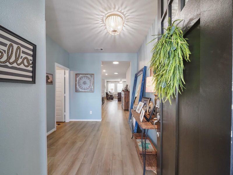 The entryway opens to warm LVP flooring and soft neutral tones, creating a bright and inviting first impression that carries throughout the main level.