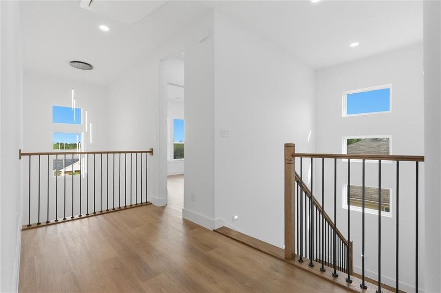 Hall featuring an upstairs landing, light wood-type flooring, and recessed lighting