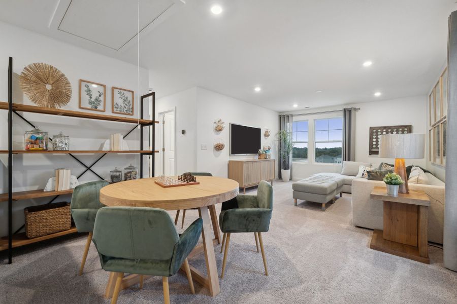 A living room with a table and chairs.