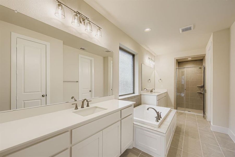 Full bath with two vanities, a garden tub, a shower stall, light tile patterned flooring, and recessed lighting