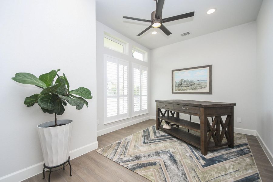 Spacious and bright study has French doors and Plantation Shutters at entry of home.