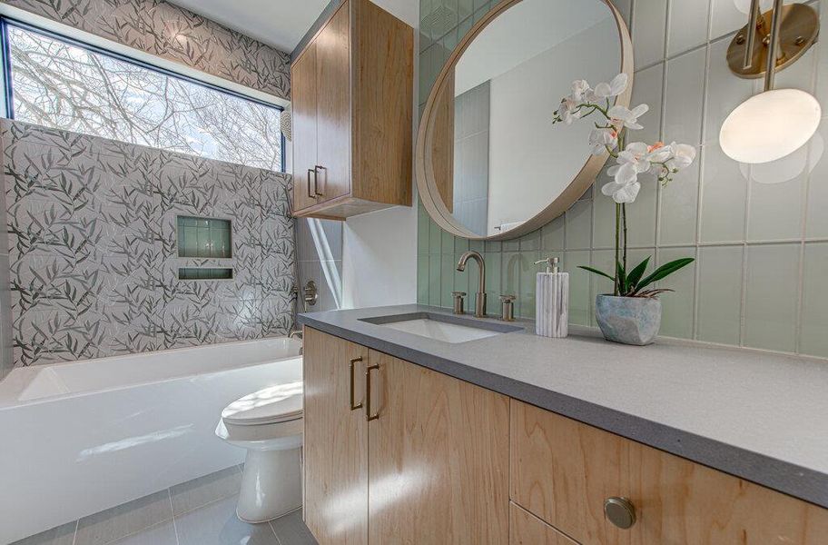 Bathroom featuring tile walls, tasteful backsplash, toilet, vanity, and tile patterned floors