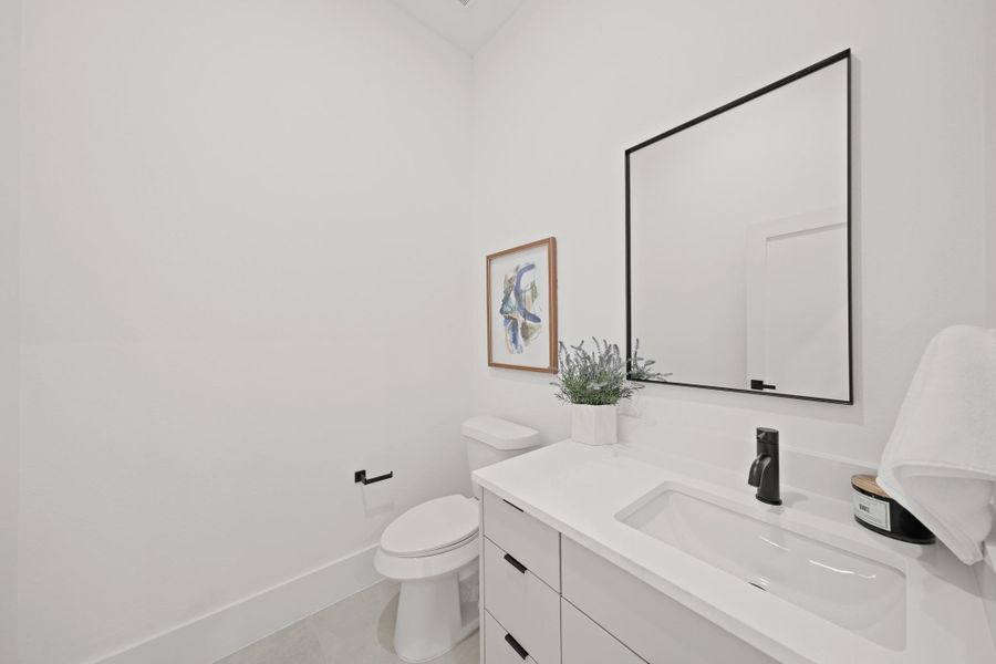 Perfect for guests, the half bath located off the second floor landing offers a quartz counter with under mount sink, a sleek black faucet, black-framed mirror, oversized tile floors, tall ceilings, wide planked baseboards,drawers, black hardware and canned lighting. Perfect for guests, the half bath located off the second floor landing offers a quartz counter with under mount sink, a sleek black faucet, black-framed mirror, oversized tile floors, tall ceilings, wide planked baseboards,drawers, black hardware and canned lighting.