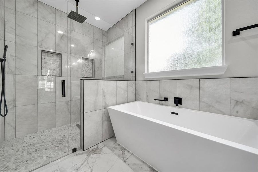 Bathroom with separate shower and tub, tile patterned flooring, and tile walls