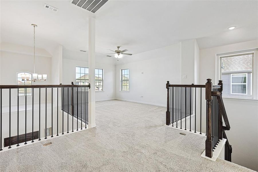 Corridor with an upstairs landing, carpet flooring, and a chandelier