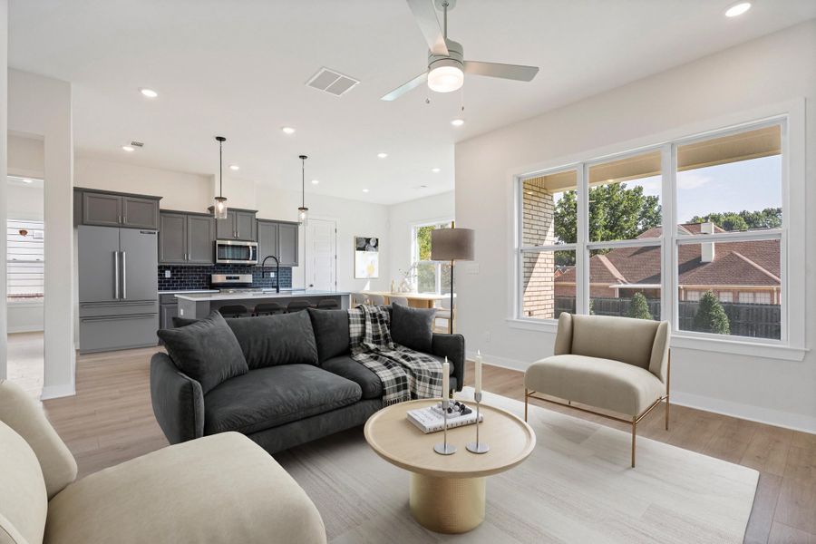 Spacious living area with wood-finish flooring, recessed lighting, and a ceiling fan