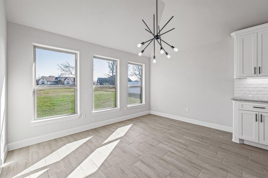 Unfurnished dining area featuring light wood-style floors and a chandelier
