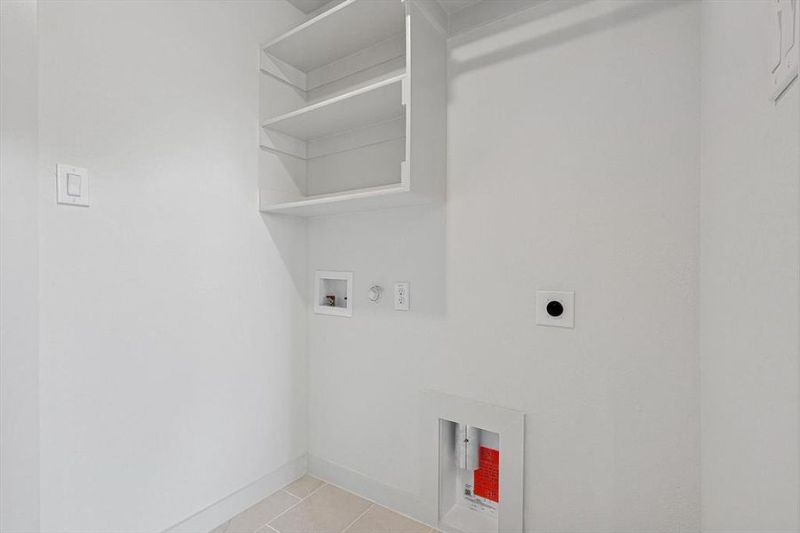 Washroom with hookup for a gas dryer, washer hookup, light tile patterned flooring, and electric dryer hookup