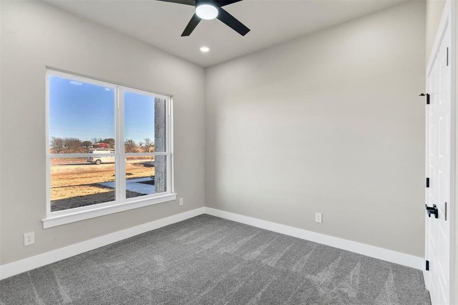 Carpeted empty room with ceiling fan