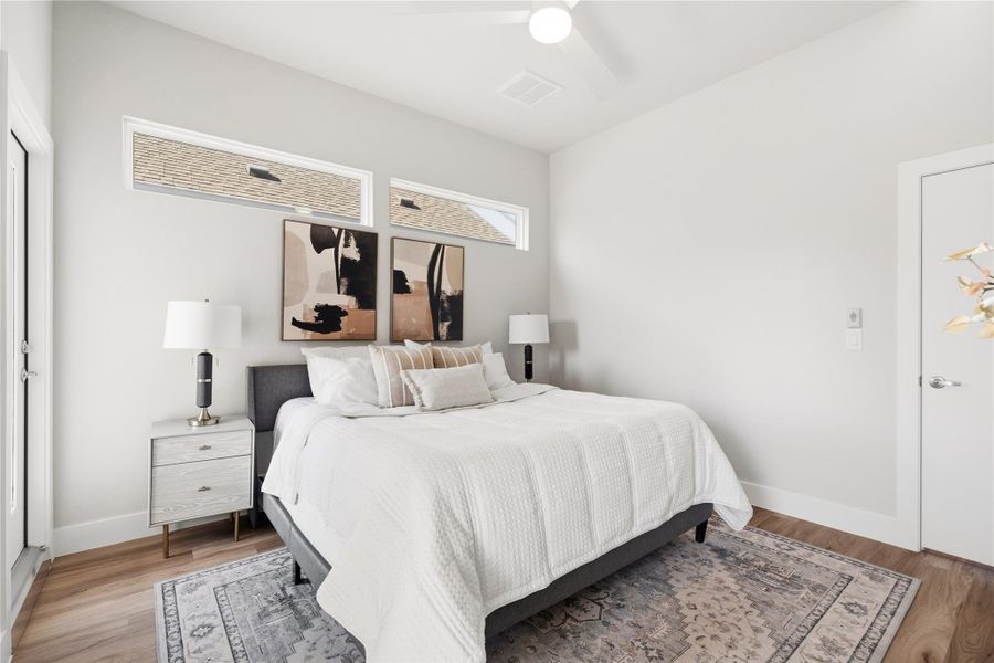 The primary bedroom is comfortably scaled to accommodate a king-size bed with dual nightstands, offering a sense of proportion that’s often missing in new construction. Positioned at the back of the home, the space feels intentionally private, quiet, balanced, and removed from the main living areas for true day-to-day comfort.