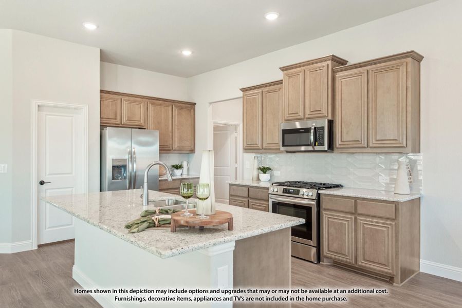 Kitchen with tan wood cabinets, granite island, and stainless steel appliances including gas range and refrigerator Kitchen with tan wood cabinets, granite island, and stainless steel appliances including gas range and refrigerator