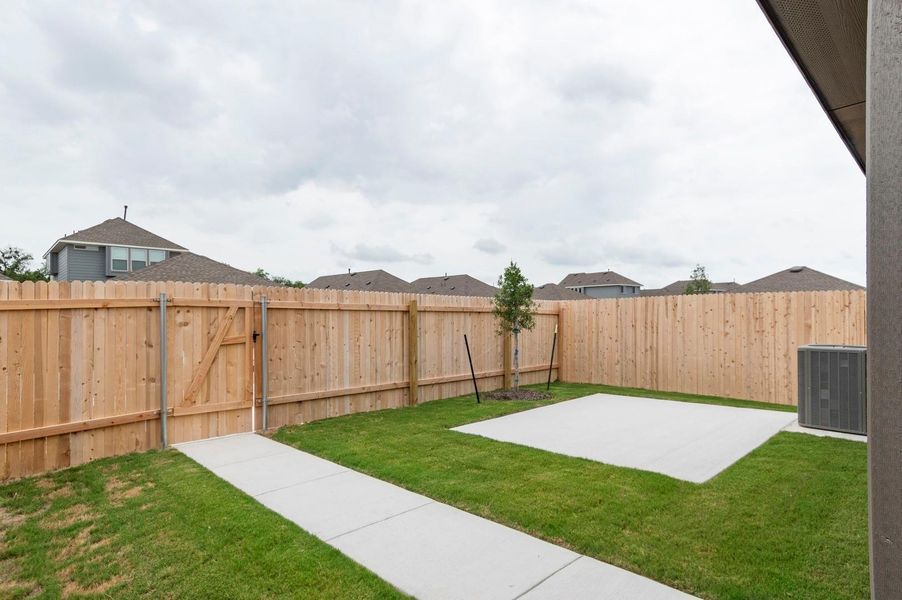 Fenced backyard featuring a patio and a gate