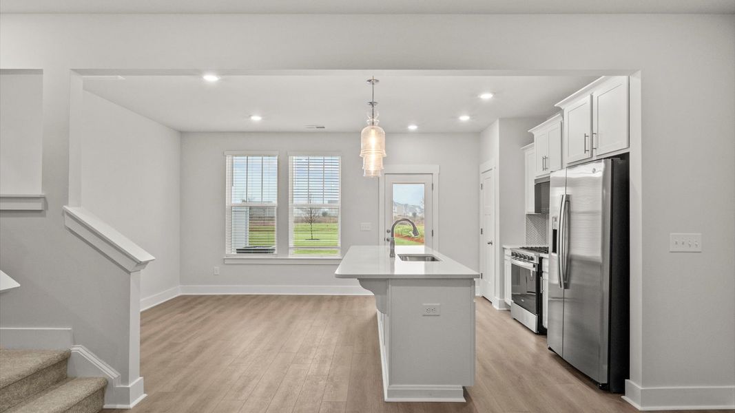 Tasteful design meets functional luxury in this kitchen with a 9-foot island and modern pendant lighting