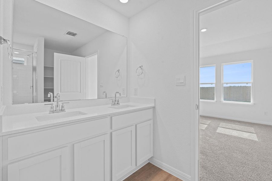 Full bath with plenty of natural light, double vanity, a shower stall, recessed lighting, and light carpet Full bath with plenty of natural light, double vanity, a shower stall, recessed lighting, and light carpet