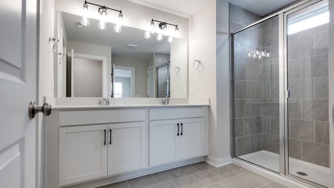 Elevated roman shower next to dual sinks