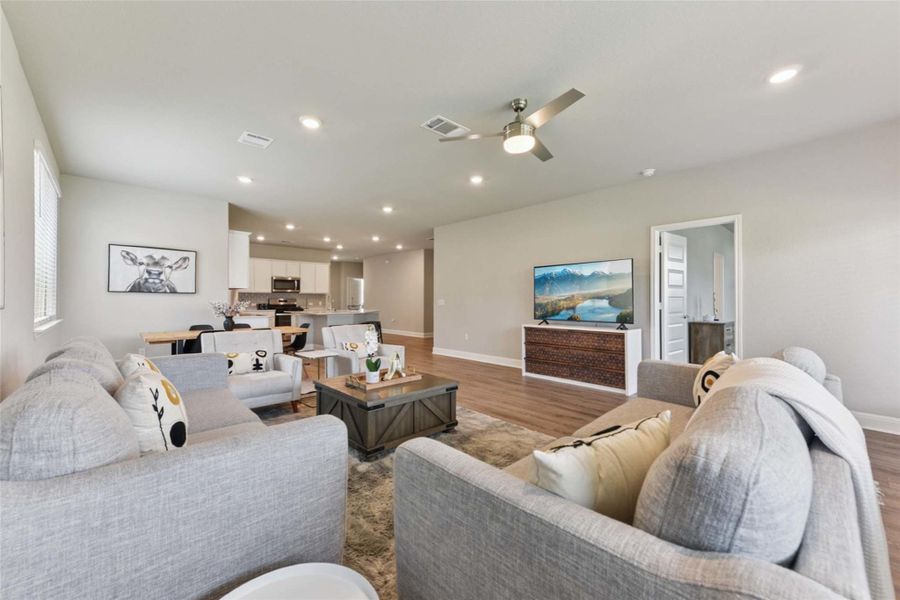 Living area featuring wood finished floors, ceiling fan, and recessed lighting Living area featuring wood finished floors, ceiling fan, and recessed lighting
