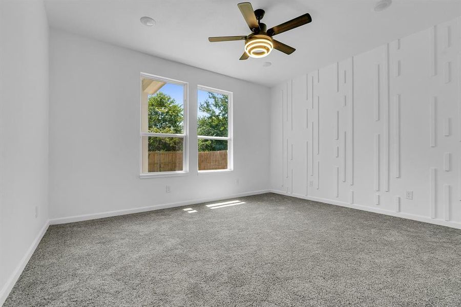 Carpeted empty room with ceiling fan