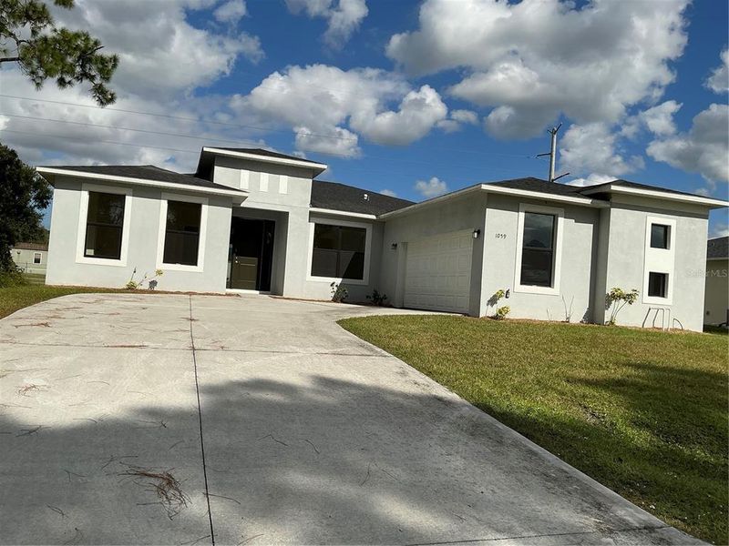 Front exterior of a new home in , Palm Bay, FL, highlighting curb appeal (Image 1).