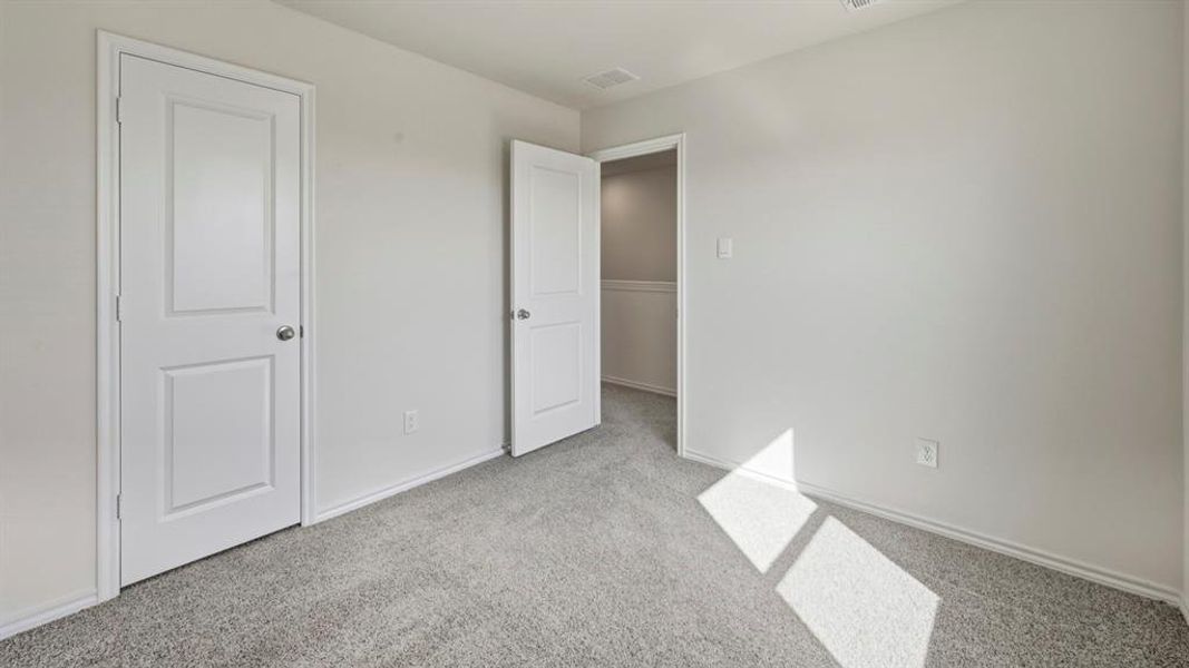 Unfurnished bedroom featuring light colored carpet and baseboards