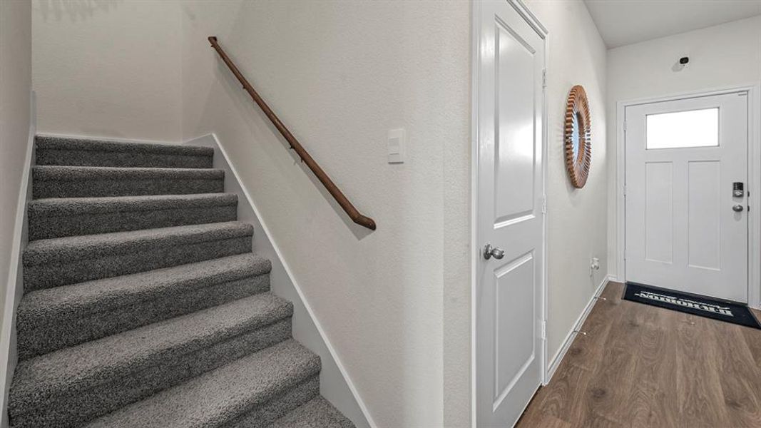 Staircase with wood finished floors and baseboards